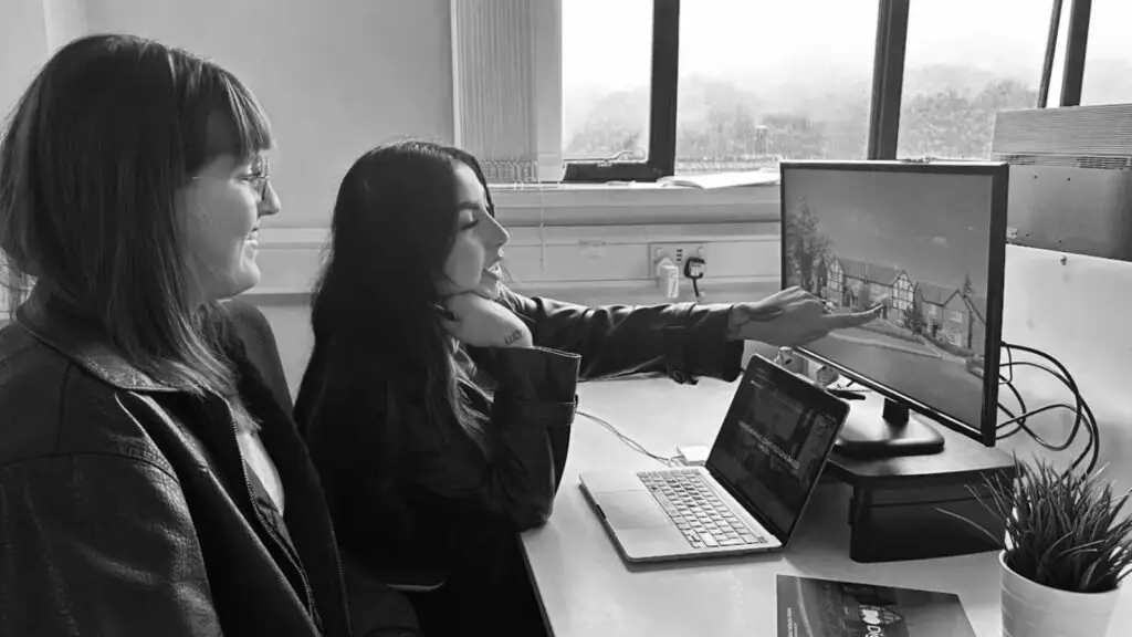 Two individuals observing a computer screen.