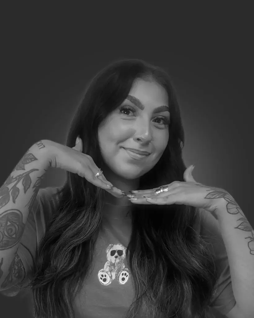 Person with tattoos posing elegantly.